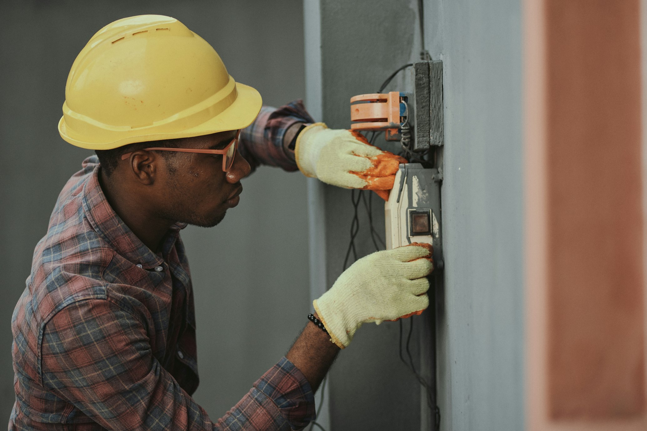 Technicien professionnel Adam Energy en combinaison de travail effectuant une installation de climatisation avec des outils spécialisés
